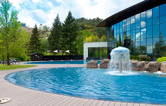 Piscina exterior com cascata junto ao edifício envidraçado do H2otel